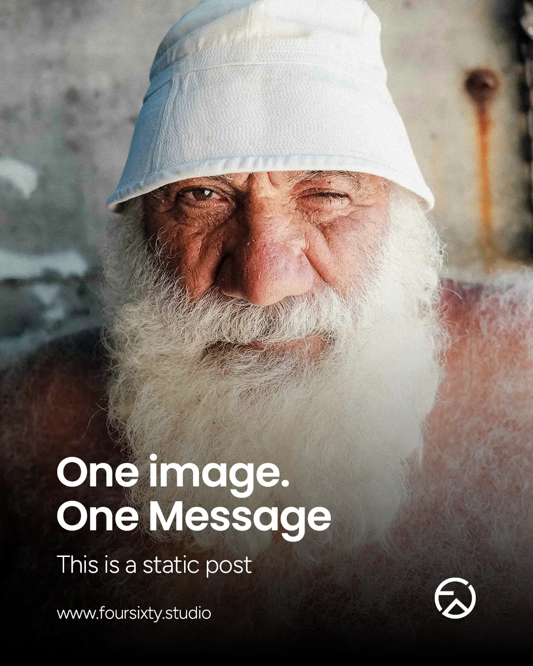 Close-up of an elderly man with a white beard and bucket hat winking at the camera.